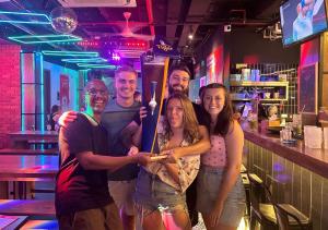 a group of people standing in a bar holding a bat at Mad Monkey Hanoi in Hanoi