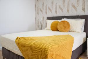ein Schlafzimmer mit einem Bett mit einer gelben Decke darauf in der Unterkunft Quinta do Além 