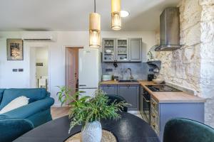 a kitchen and living room with a couch and a table at Fortuna in Nerežišće