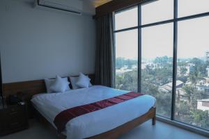 1 dormitorio con 1 cama y ventanas grandes en JAKAS Resource Center en Helkunda