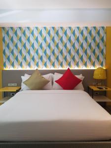 a bedroom with a large white bed with colorful pillows at Lagùn Hotel in El Nido +41 photos