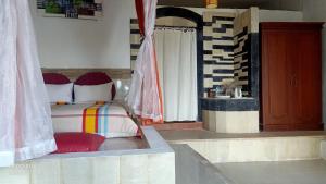 Rara Villas Lombok في سينغيغي: غرفة نوم فيها سرير وكرسي