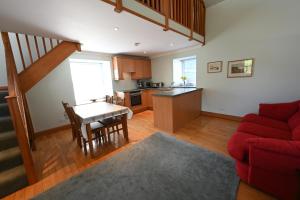 un soggiorno con divano rosso e una cucina di Swallow Cottage a Fort William