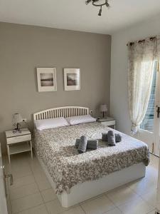 a bedroom with a bed and two tables and a window at Bellver 1, Ciutadella-Cala Blanca in Cala Blanca +24 photos