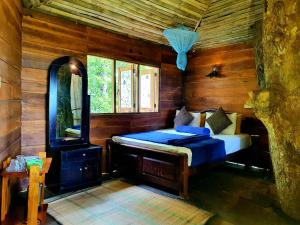 sypialnia z łóżkiem w drewnianym pokoju w obiekcie The Winsome & Tree House w mieście Ella