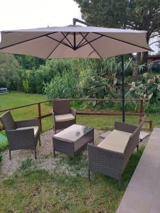 a patio with a table and chairs and an umbrella at Casa Toscana in Lorenzana