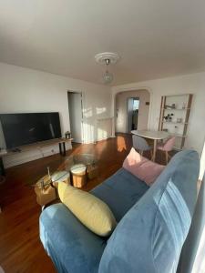 sala de estar con sofá azul y TV en Appartement T3 Anglet 67m2, en Anglet