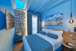 a blue bedroom with a large bed with blue walls at 73 Boutique Hotel in Como
