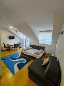 Cette chambre comprend un lit, un canapé et une table. dans l'établissement Apartman Kata, à Vrnjačka Banja