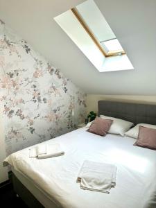 a bedroom with a large white bed with a skylight at KAPTOL Rooms in Zagreb