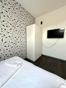 a bedroom with a bed and a tv on a wall at KAPTOL Rooms in Zagreb