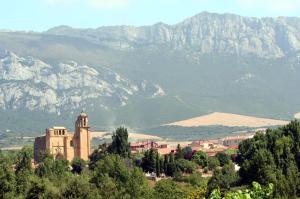 a building on a hill with mountains in the background at Agroturismo el Encuentro in Leza