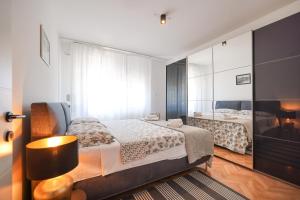 a bedroom with a large bed and a mirror at Oscar & Leo Apartments in Zadar