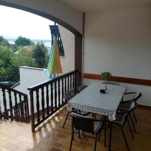a table and chairs on a balcony with an umbrella at Apartments Delfin in Posedarje