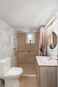 a bathroom with a toilet and a sink and a mirror at Casa di Calma & Casa di Luce Rhodes Apartments in Rhodes Town