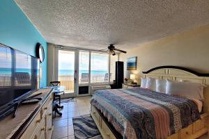 een slaapkamer met een bed en uitzicht op de oceaan bij Pirates Cove Condo Unit #209 in Daytona Beach