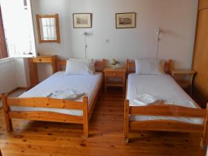 - 2 lits dans une chambre dotée de parquet dans l'établissement Aggela Guesthouse, à Skopelos