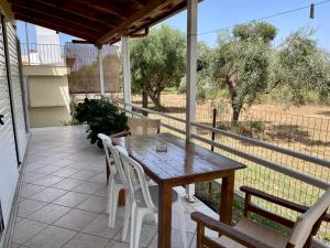 a wooden table and chairs on the porch of a house at my Green Villa in Zakharo