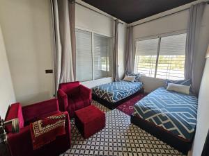 ein kleines Zimmer mit einem Bett, einem Stuhl und einem Fenster in der Unterkunft Villa de Ferme Wafaa - Location de Rêve avec Piscine près de Mazagan in El Jadida