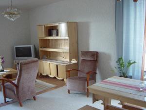 a living room with a desk and chairs and a table at Huoneistohotelli Teekki in Muuruvesi