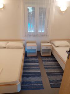 a small room with two beds and a window at Apartments Delfin in Posedarje