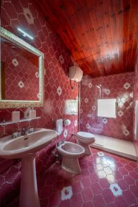 a pink bathroom with a sink and a toilet at La torretta sul cortile in Monteroduni
