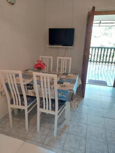 a dining room table with four chairs and a television at Apartments Delfin in Posedarje