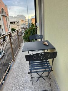 a black table and a chair on a balcony at Tropical house in Lecce