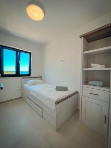 a bedroom with a bed and a large window at Apartman Lana&Bruno in Mandre