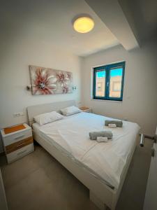 a bedroom with a large white bed with towels on it at Apartman Lana&Bruno in Mandre