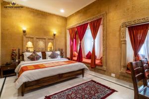 a bedroom with a large bed with red curtains at Gaji Hotel Jaisalmer in Jaisalmer
