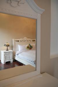 a reflection of a bedroom with a bed in a mirror at Dalat Terrasse Des Roses Villa in Da Lat