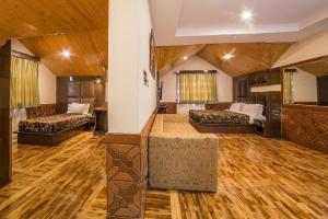 un ampio soggiorno con 2 letti e pavimenti in legno di OPERA INN a Srinagar