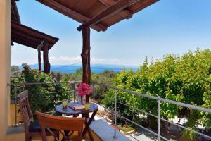 a patio with a table and chairs on a balcony at Alkifron Hotel in Kala Nera