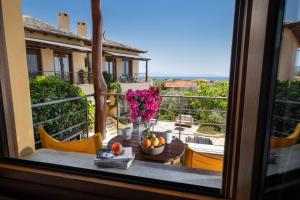 a view from a window of a balcony with a table with flowers at Alkifron Hotel in Kala Nera