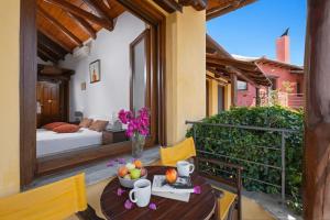 a balcony with a table with a bowl of fruit on it at Alkifron Hotel in Kala Nera