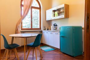 a kitchen with a table and a blue refrigerator at B&B LA VILLA in Voghera