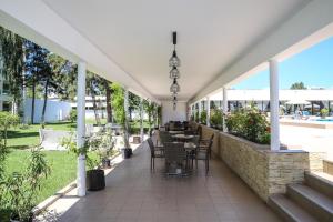an outdoor patio with tables and chairs and plants at Hotel Dorna in Mamaia