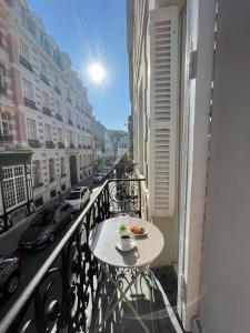 una mesa en un balcón con un plato de comida en Le Bleu, en Trouville-sur-Mer