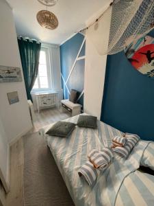 um quarto com uma cama grande e paredes azuis em Le Bleu em Trouville-sur-Mer