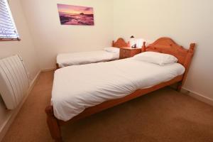 two twin beds in a room with at Ash, Birch and Rowan Cabins in Onich