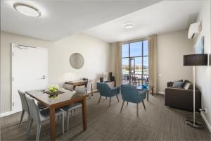 a living room with a table and chairs at Quest Albury on Townsend in Albury