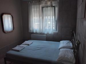 Dormitorio pequeño con cama y ventana en Ariadne Apartments, en Néa Michanióna