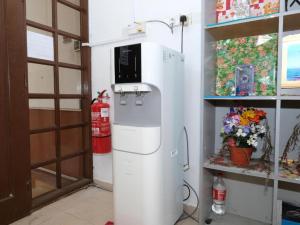 a white refrigerator with a microwave on top of it at Hotel De'light Villa in Kota Bharu