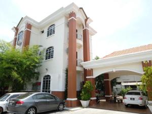 dos autos estacionados frente a una casa en Hotel De'light Villa, en Kota Bharu