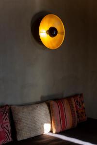 a light hanging above a couch with a pillow at Life Gallery Hotel in Korçë