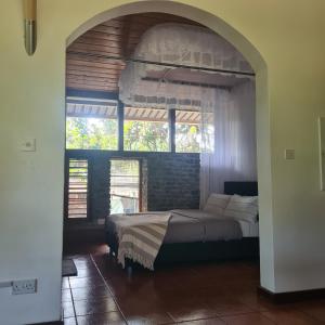a bedroom with a bed and a large window at Olosiva Oasis in Arusha