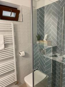 La salle de bains est pourvue de toilettes et d'une douche en verre. dans l'établissement Morris Vacka, à Veszprém