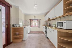 a kitchen with white appliances and a microwave at Brook Barn in Malborough