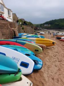 a bunch of surfboards lined up on a beach at Brook Barn in Malborough